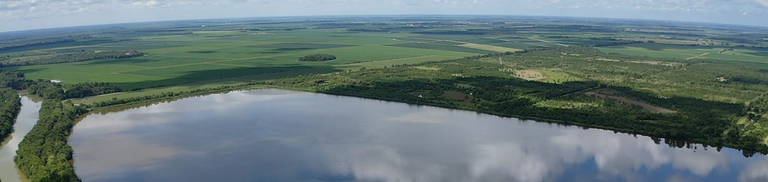 aerial shot of farmland around a large reservoir